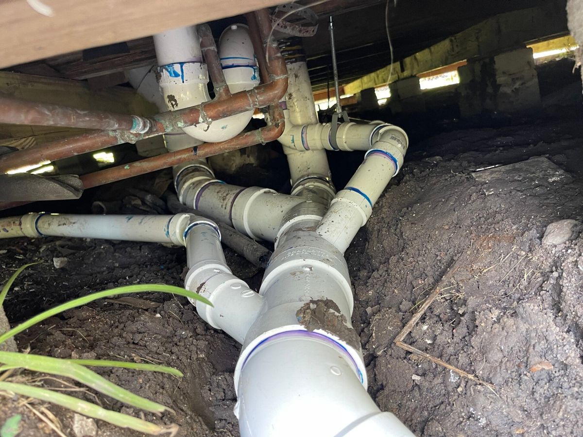 New PVC drain and vent fittings under a pier-and-beam house