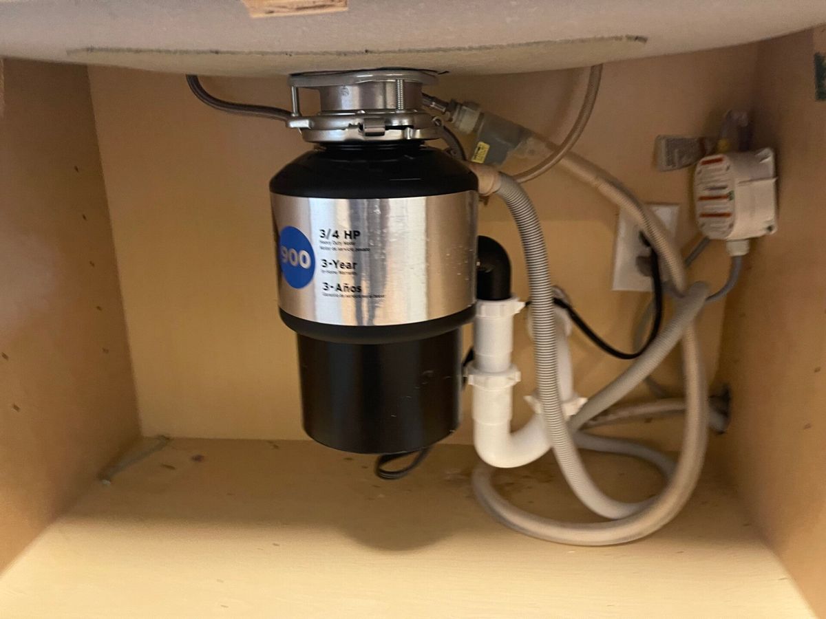 New garbage disposal installed under a kitchen sink