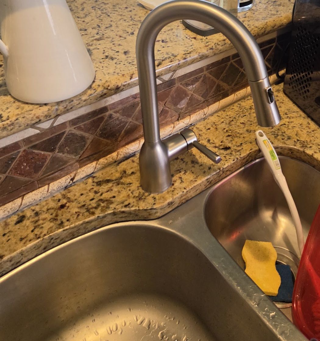 New kitchen faucet installed over a stainless sink