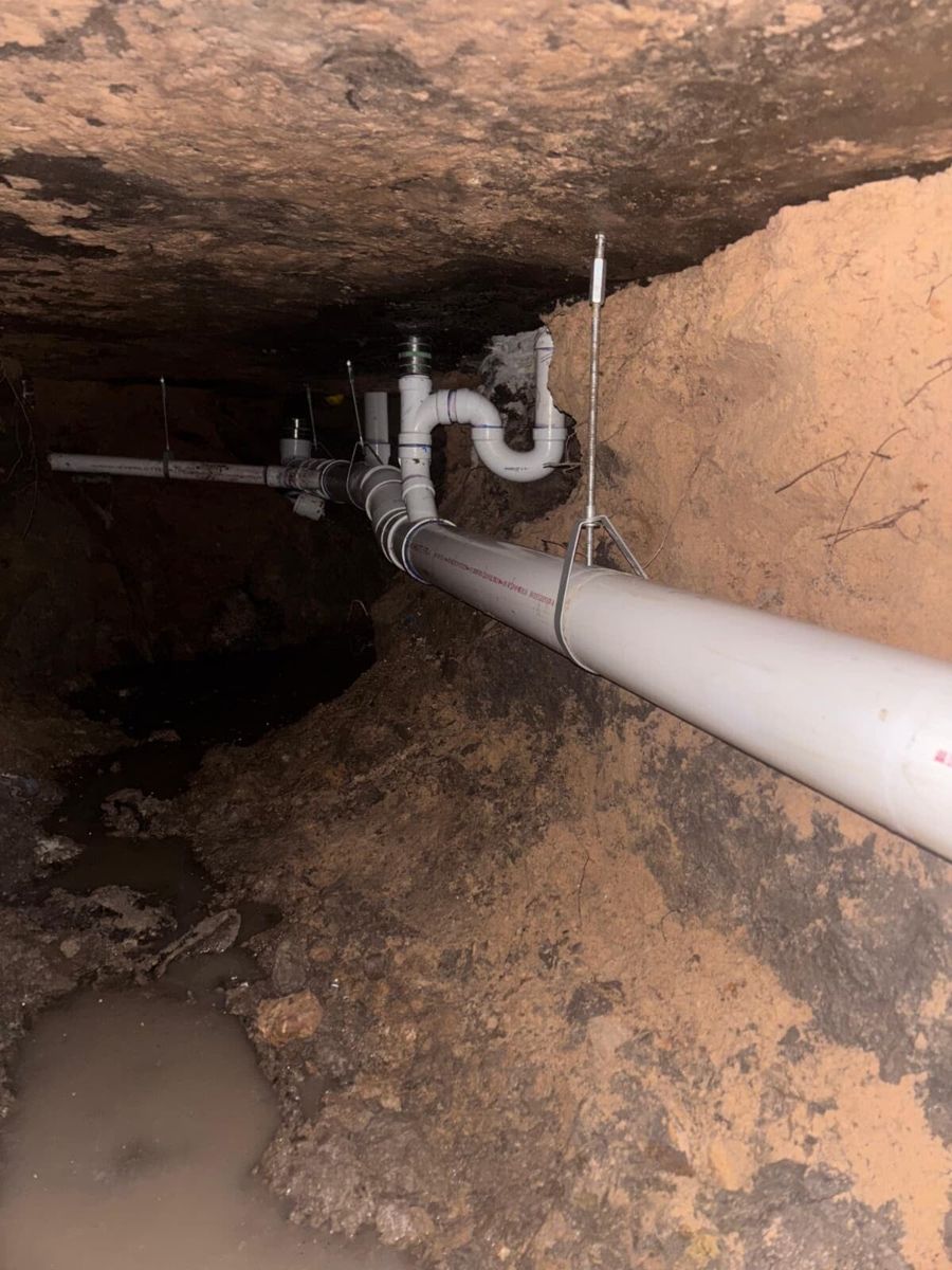 New PVC drain line installed inside an under-slab tunnel